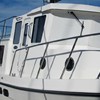 lots of opening port lights, windows, and doors each side of pilothouse